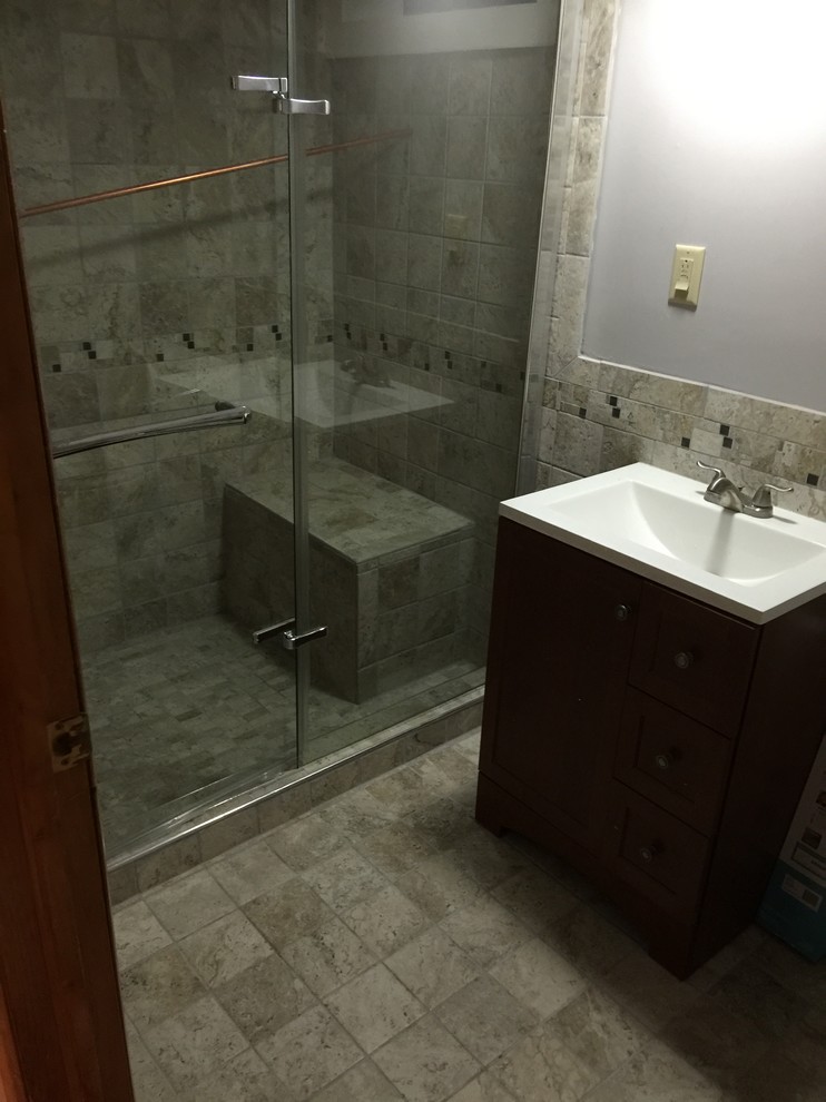 Example of a small classic 3/4 ceramic tile and gray tile ceramic tile and gray floor alcove shower design in New York with dark wood cabinets, gray walls, a drop-in sink, a hinged shower door, shaker cabinets, a two-piece toilet and solid surface countertops