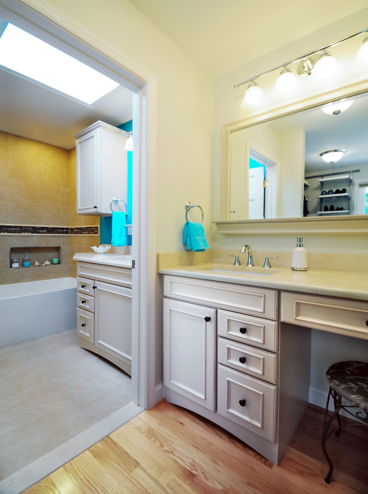 Mid-sized elegant master multicolored tile and porcelain tile light wood floor bathroom photo in DC Metro with raised-panel cabinets, beige cabinets, quartz countertops, a one-piece toilet, white walls and an undermount sink