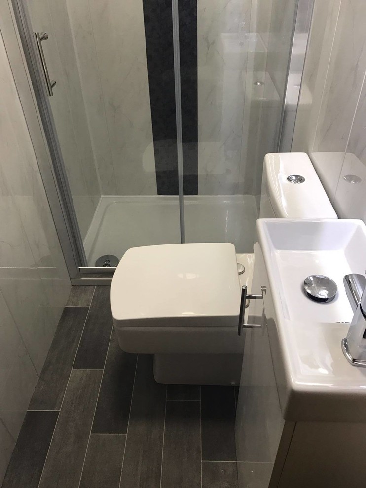 Inspiration för små klassiska en-suite badrum, med släta luckor, vita skåp, en kantlös dusch, en toalettstol med separat cisternkåpa, grå väggar och vinylgolv