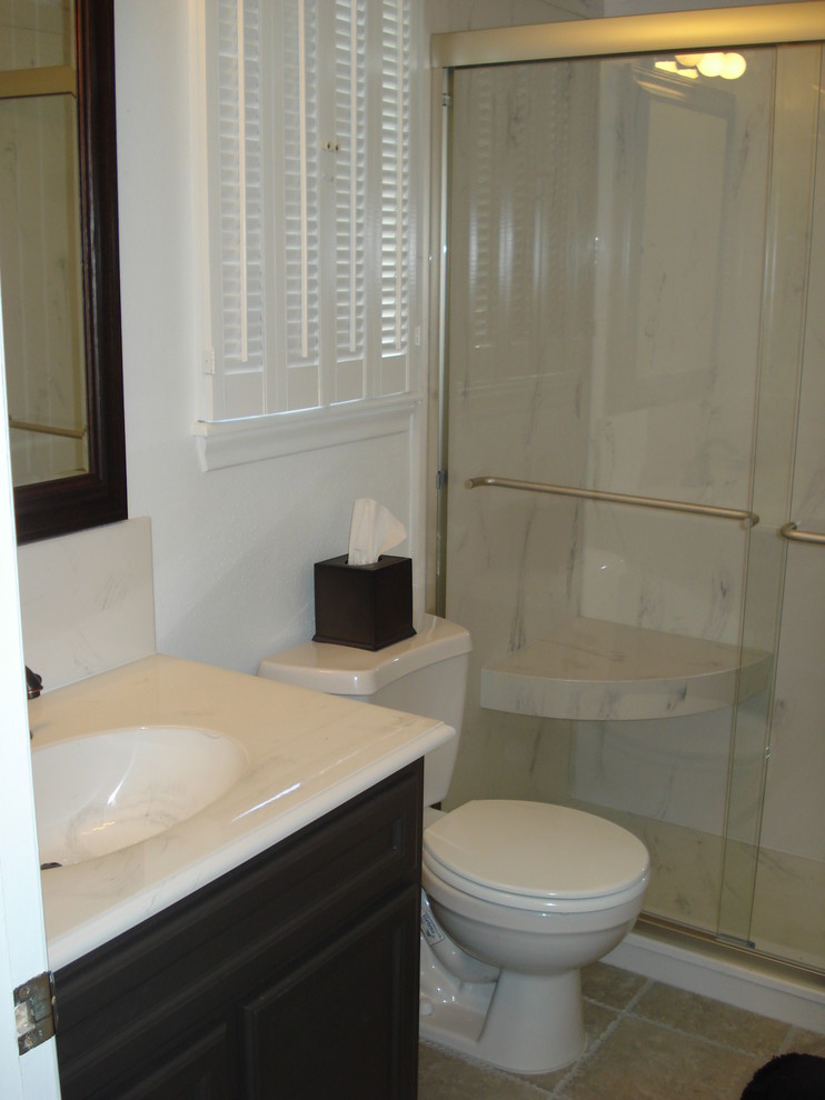Medium sized traditional shower room bathroom in Houston with flat-panel cabinets, black cabinets, an alcove shower, a two-piece toilet, white walls, porcelain flooring and an integrated sink.