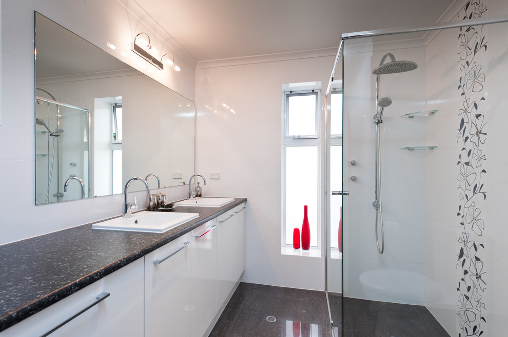 Kleines Modernes Duschbad mit weißen Schränken, Duschnische, Toilette mit Aufsatzspülkasten, weißen Fliesen, weißer Wandfarbe und Einbauwaschbecken in Sonstige