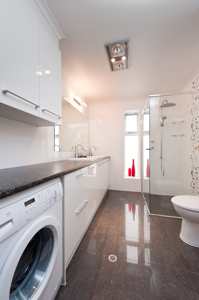 На фото: маленькая ванная комната со стиральной машиной в стиле модернизм с белыми фасадами, душем в нише, унитазом-моноблоком, белой плиткой, белыми стенами, душевой кабиной и накладной раковиной для на участке и в саду с