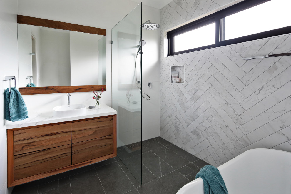 Свежая идея для дизайна: ванная комната в современном стиле с плоскими фасадами, фасадами цвета дерева среднего тона, душем в нише, белой плиткой, накладной раковиной, серым полом и белой столешницей - отличное фото интерьера