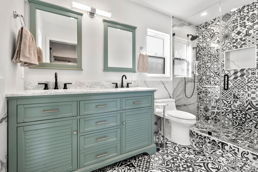 Klassisk inredning av ett stort grå grått badrum med dusch, med turkosa skåp, svart och vit kakel, porslinskakel, klinkergolv i porslin, marmorbänkskiva, flerfärgat golv, luckor med lamellpanel, en dusch i en alkov, en toalettstol med hel cisternkåpa, vita väggar, ett undermonterad handfat och dusch med gångjärnsdörr