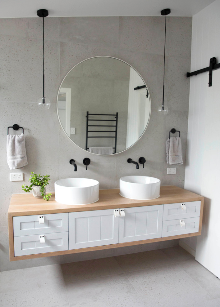 Immagine di una stanza da bagno padronale moderna con ante in stile shaker, ante in legno chiaro, piastrelle grigie, piastrelle di cemento, pareti grigie, pavimento in cementine, lavabo a consolle e top in legno