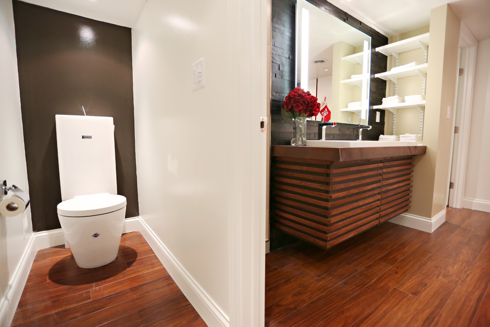 Exemple d'une salle de bain tendance en bois brun de taille moyenne avec une grande vasque, un placard en trompe-l'oeil, un plan de toilette en cuivre, une baignoire encastrée, une douche ouverte, WC à poser, un carrelage noir, un carrelage de pierre, un mur beige et un sol en bois brun.