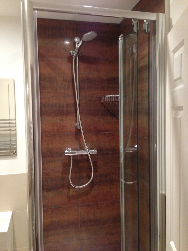 Foto di una piccola stanza da bagno minimalista con lavabo sospeso, doccia ad angolo, piastrelle marroni, piastrelle in gres porcellanato e pavimento in gres porcellanato