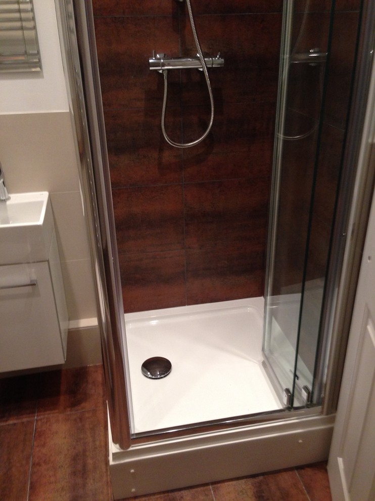 Foto di una piccola stanza da bagno minimalista con doccia ad angolo, piastrelle marroni, piastrelle in gres porcellanato e pavimento in gres porcellanato