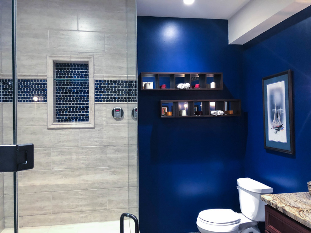 Klassisches Duschbad mit braunen Schränken, Eckdusche, Toilette mit Aufsatzspülkasten, blauer Wandfarbe, integriertem Waschbecken, Quarzwerkstein-Waschtisch, Falttür-Duschabtrennung, bunter Waschtischplatte, Einzelwaschbecken und freistehendem Waschtisch