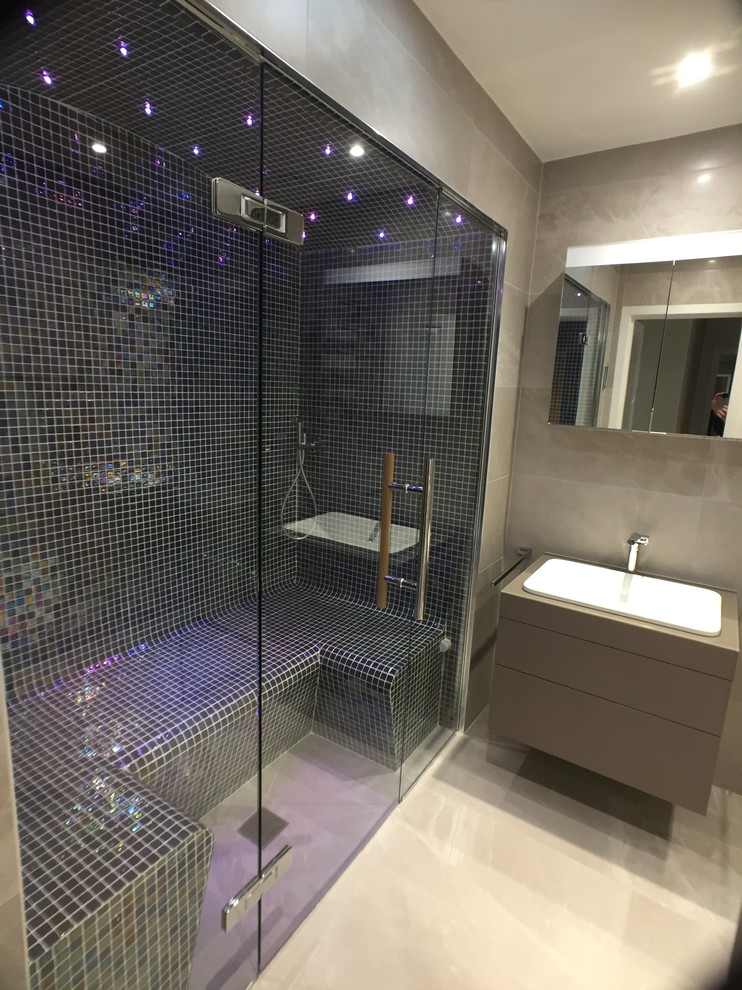 Photo of a sauna bathroom in Edinburgh with flat-panel cabinets, brown cabinets, multi-coloured tiles, mosaic tiles, porcelain flooring and beige floors.