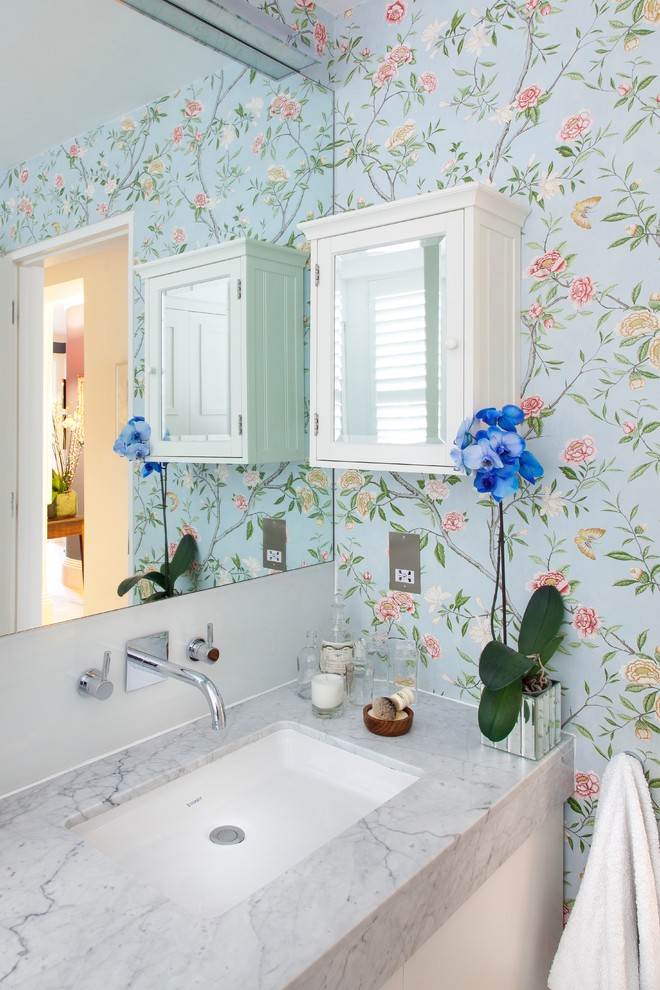 Cette photo montre une petite salle de bain tendance pour enfant avec un combiné douche/baignoire, un mur blanc, un sol en marbre, un lavabo intégré et un plan de toilette en marbre.