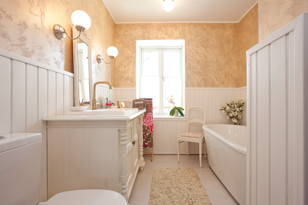 Ejemplo de cuarto de baño actual con lavabo encastrado, puertas de armario blancas, bañera exenta, sanitario de dos piezas y armarios con paneles empotrados