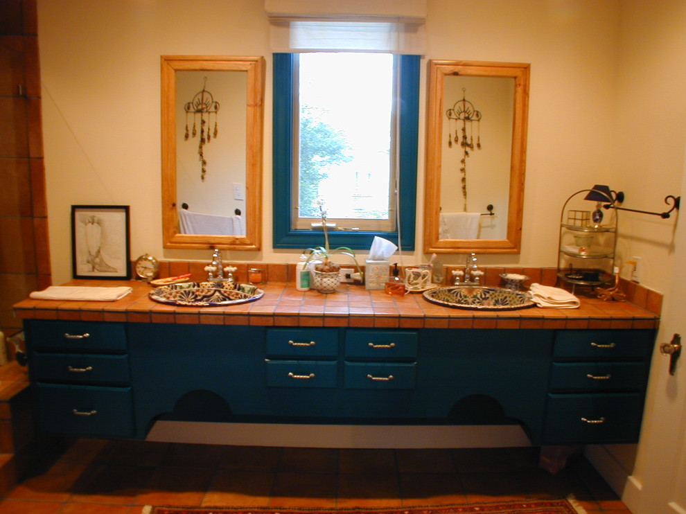 Foto på ett vintage badrum, med blå skåp, perrakottakakel och ett nedsänkt handfat