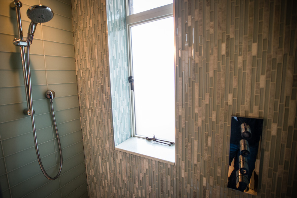 Inredning av ett modernt litet badrum med dusch, med vita skåp, ett badkar i en alkov, en dusch/badkar-kombination, en toalettstol med separat cisternkåpa, blå kakel, grön kakel, glaskakel, flerfärgade väggar, ett integrerad handfat och bänkskiva i glas