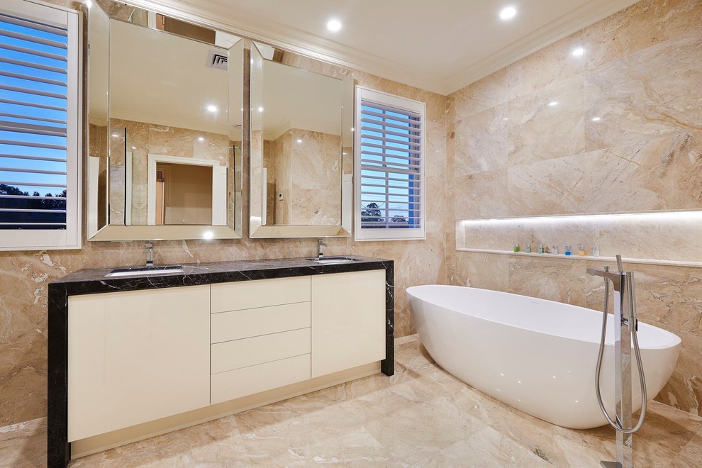 Immagine di una stanza da bagno padronale contemporanea con ante lisce, ante bianche, vasca freestanding, pareti beige, lavabo sottopiano e pavimento beige