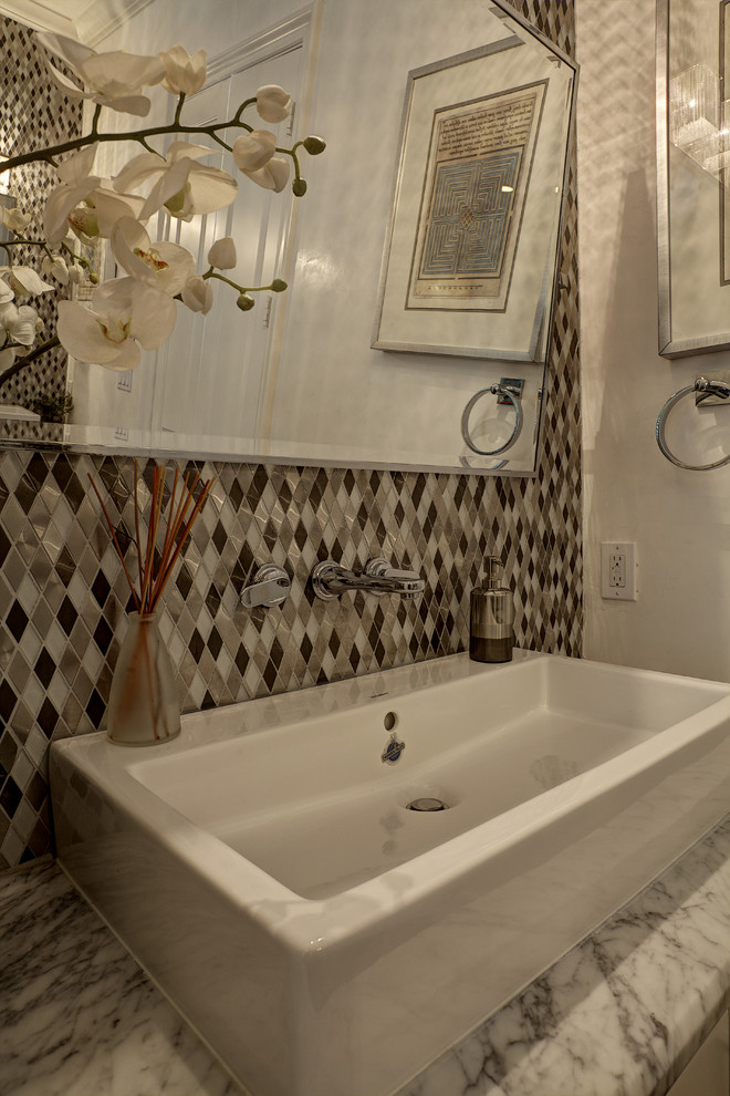 Foto di una stanza da bagno mediterranea con lavabo a bacinella, top in marmo e piastrelle di vetro