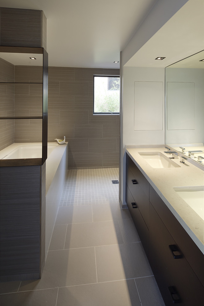 На фото: главная ванная комната в стиле модернизм с врезной раковиной, плоскими фасадами, темными деревянными фасадами, открытым душем, бежевой плиткой, керамической плиткой, серыми стенами, полновстраиваемой ванной и открытым душем