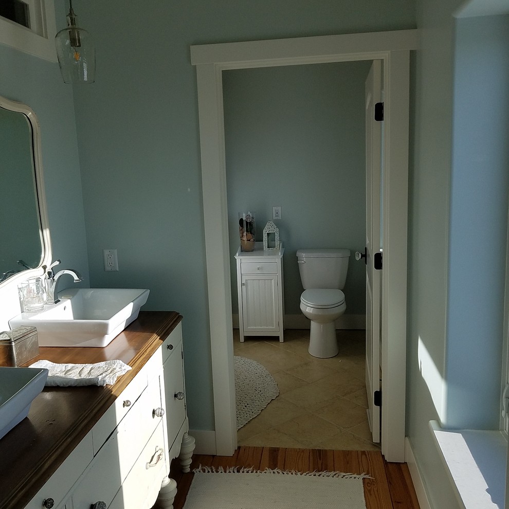 На фото: главная ванная комната среднего размера в стиле кантри с фасадами островного типа, искусственно-состаренными фасадами, унитазом-моноблоком, зелеными стенами, полом из керамической плитки, настольной раковиной и коричневым полом с