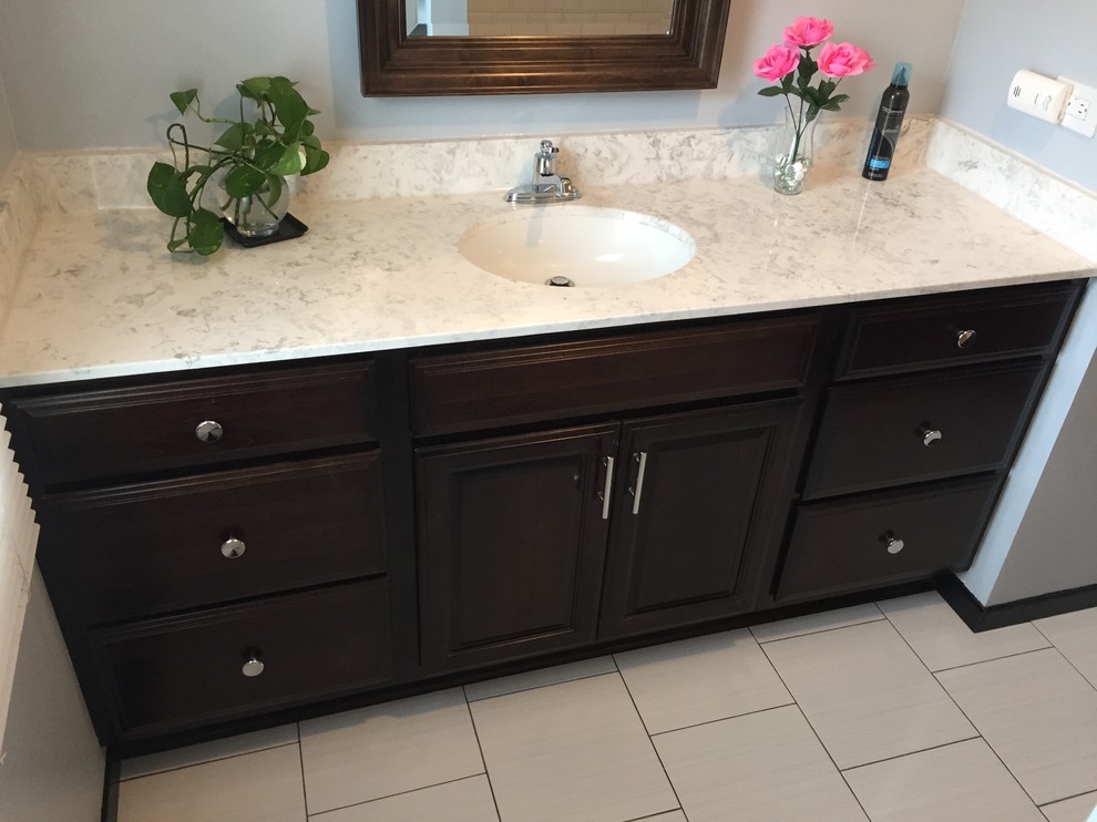 Example of a small transitional master white tile and ceramic tile porcelain tile alcove shower design in Chicago with raised-panel cabinets, dark wood cabinets, a two-piece toilet, an integrated sink and solid surface countertops