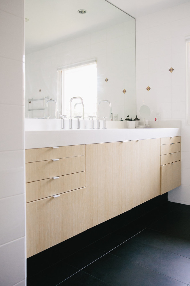 Inredning av ett modernt mellanstort en-suite badrum, med släta luckor, skåp i ljust trä, ett fristående badkar, en dusch i en alkov, vita väggar, skiffergolv, bänkskiva i kvartsit, svart golv, dusch med skjutdörr och ett integrerad handfat