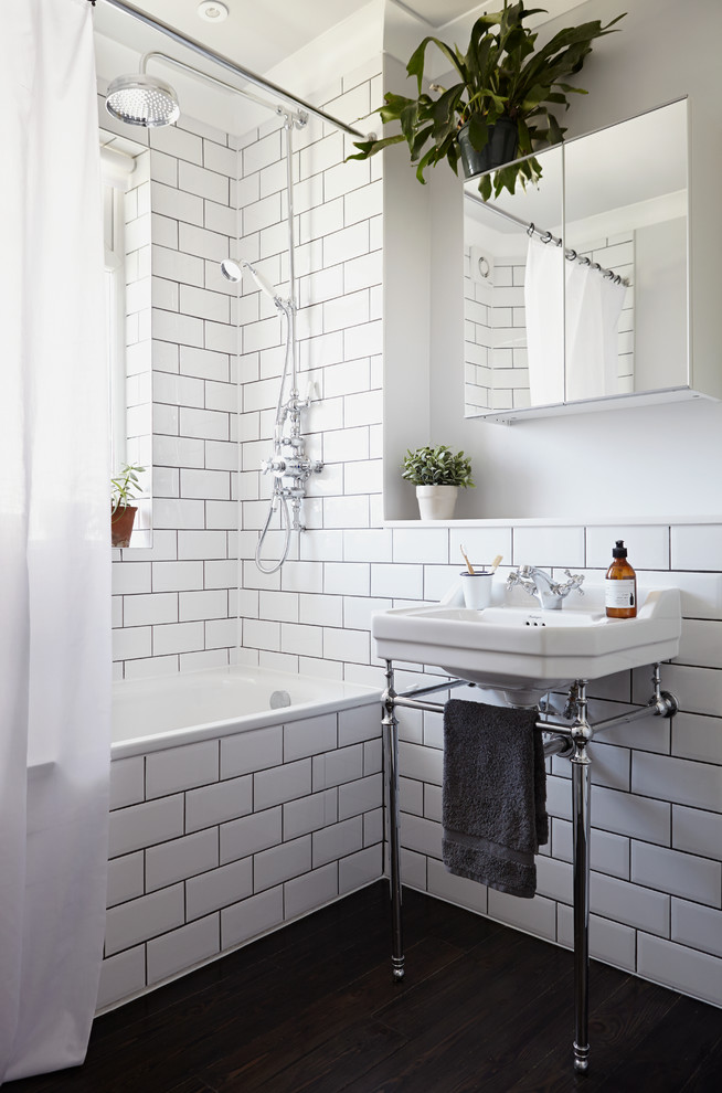 Design ideas for a traditional bathroom in London with a console sink, an alcove bath, a shower/bath combination, white walls, dark hardwood flooring, white tiles and a single sink.