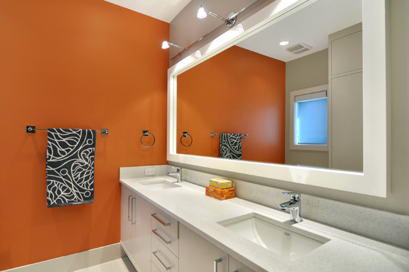 Modernes Badezimmer mit flächenbündigen Schrankfronten, weißen Schränken, oranger Wandfarbe, Unterbauwaschbecken und Quarzwerkstein-Waschtisch in Calgary