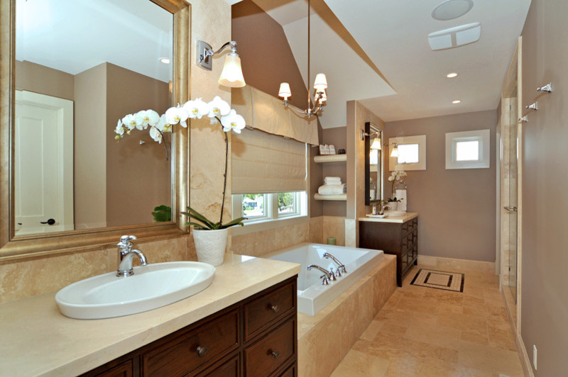Imagen de cuarto de baño tradicional con puertas de armario de madera en tonos medios, bañera encastrada, paredes marrones y suelo de travertino