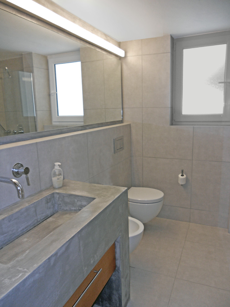 This is an example of a medium sized modern shower room bathroom in New York with a wall-mounted sink, flat-panel cabinets, medium wood cabinets, concrete worktops, a corner shower, a wall mounted toilet, grey tiles, porcelain tiles, grey walls and porcelain flooring.