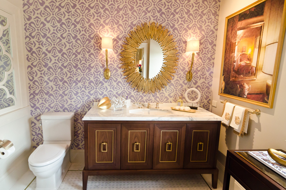 Esempio di una stanza da bagno design con lavabo a consolle, top in marmo e pareti viola