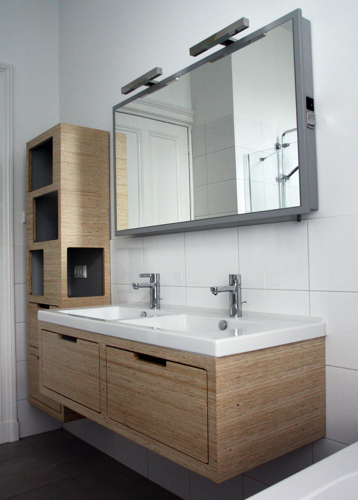 На фото: ванная комната в стиле модернизм с светлыми деревянными фасадами с