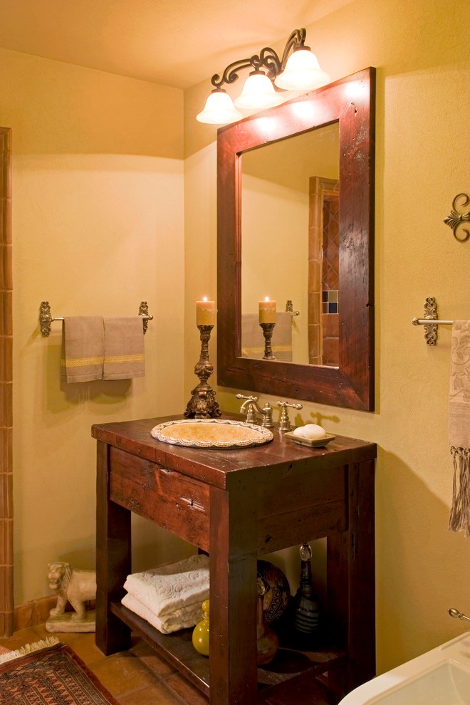 Идея дизайна: ванная комната среднего размера в стиле фьюжн с накладной раковиной, фасадами островного типа, искусственно-состаренными фасадами, столешницей из дерева, терракотовой плиткой, желтыми стенами, полом из терракотовой плитки, душевой кабиной, накладной ванной, душем в нише и раздельным унитазом