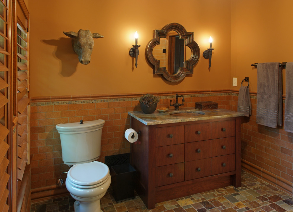 Bild på ett mellanstort amerikanskt badrum med dusch, med ett undermonterad handfat, möbel-liknande, skåp i mellenmörkt trä, ett undermonterat badkar, en kantlös dusch, en toalettstol med separat cisternkåpa, flerfärgad kakel, perrakottakakel, orange väggar och klinkergolv i terrakotta