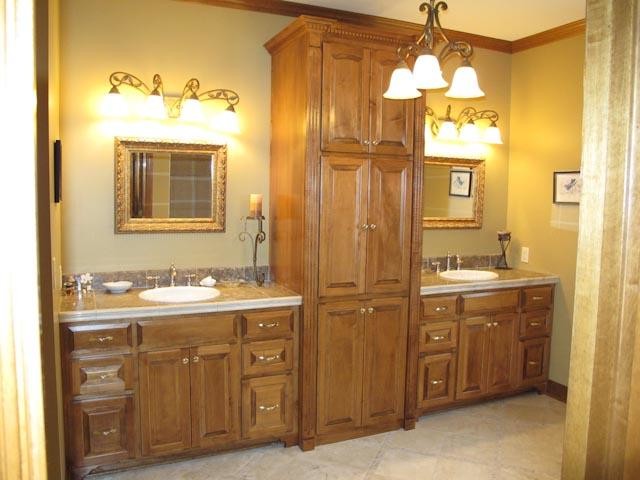 Example of a master porcelain tile bathroom design in Kansas City with a drop-in sink, raised-panel cabinets, light wood cabinets, granite countertops and green walls