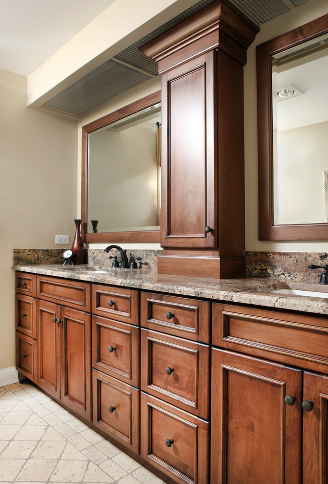 Klassisk inredning av ett stort en-suite badrum, med ett undermonterad handfat, luckor med infälld panel, skåp i mellenmörkt trä, granitbänkskiva, beige väggar och travertin golv
