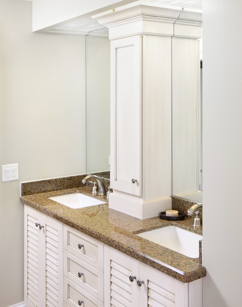Imagen de cuarto de baño clásico de tamaño medio con lavabo bajoencimera, armarios con paneles empotrados, puertas de armario blancas, encimera de granito, paredes beige y aseo y ducha