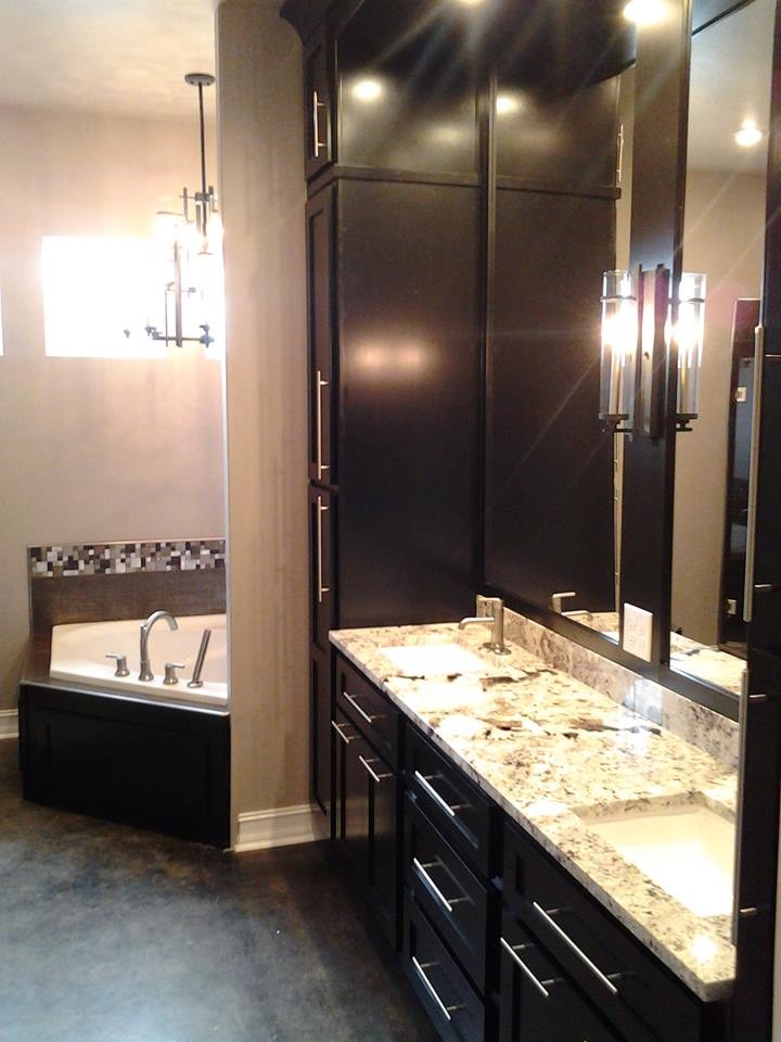 Exemple d'une salle de bain principale tendance de taille moyenne avec un lavabo encastré, un placard à porte plane, des portes de placard noires, un plan de toilette en granite, une baignoire d'angle, un mur gris et un sol en ardoise.