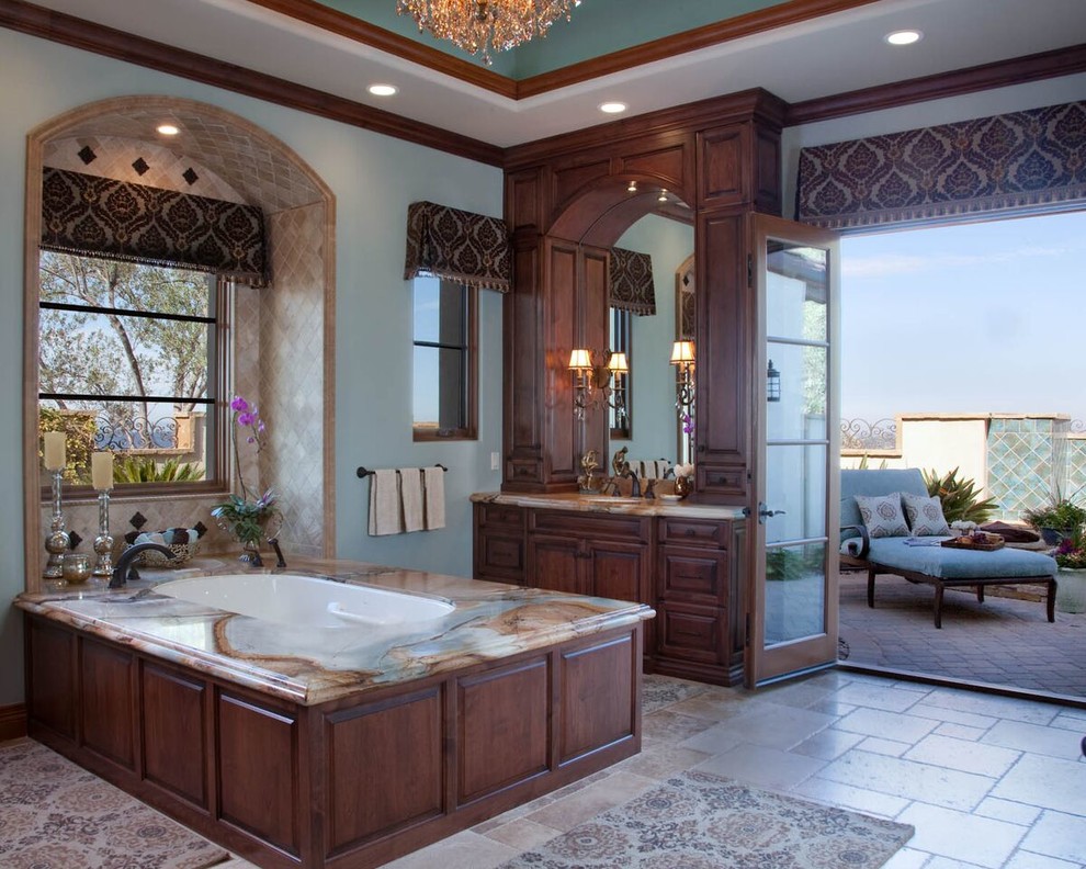 Inspiration for a large traditional ensuite bathroom in San Diego with raised-panel cabinets, dark wood cabinets, a submerged bath, ceramic tiles, blue walls, ceramic flooring, a submerged sink, marble worktops, beige tiles and an alcove shower.