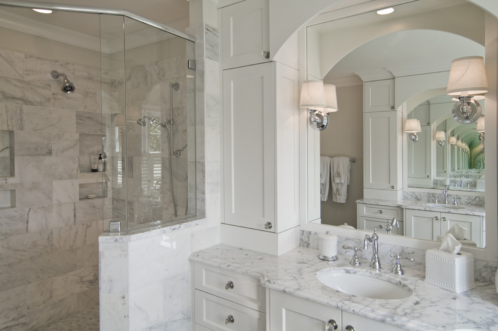 На фото: ванная комната в классическом стиле с врезной раковиной, фасадами с утопленной филенкой, белыми фасадами, угловым душем и белой плиткой с