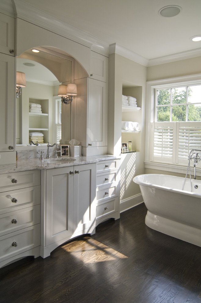シャーロットにあるトラディショナルスタイルのおしゃれなお風呂の窓 (アンダーカウンター洗面器、シェーカースタイル扉のキャビネット、白いキャビネット、置き型浴槽) の写真