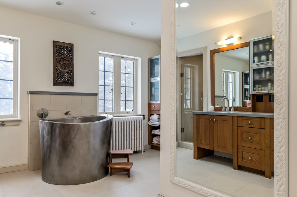 Inredning av ett modernt stort en-suite badrum, med ett nedsänkt handfat, möbel-liknande, skåp i mellenmörkt trä, bänkskiva i betong, ett fristående badkar, beige kakel, cementkakel, vita väggar och klinkergolv i keramik