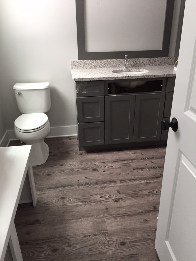 This is an example of a medium sized traditional ensuite bathroom in Grand Rapids with an integrated sink, recessed-panel cabinets, grey cabinets, marble worktops, a bidet, grey walls and dark hardwood flooring.