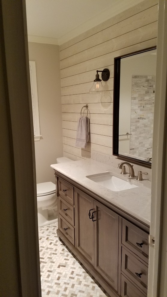 Rustik inredning av ett mellanstort badrum med dusch, med grå väggar, ett undermonterad handfat, luckor med infälld panel, ett badkar i en alkov, en dusch/badkar-kombination, en toalettstol med separat cisternkåpa, stenkakel och bruna skåp