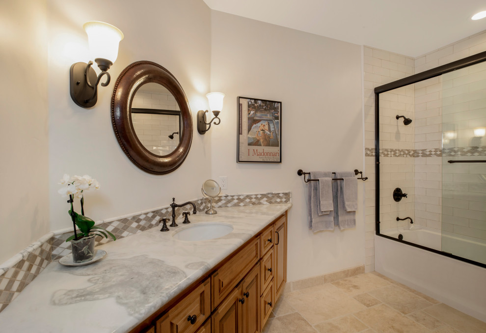 Immagine di una stanza da bagno mediterranea con vasca/doccia, piastrelle bianche, pareti bianche, lavabo sottopiano, pavimento beige e porta doccia scorrevole