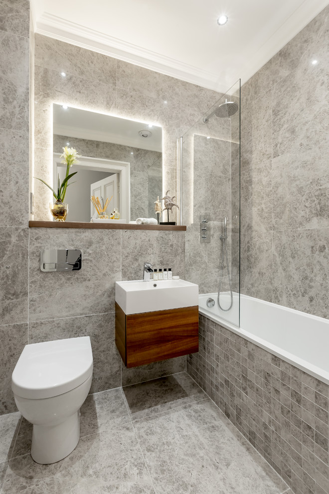 Foto di una stanza da bagno padronale design con ante lisce, ante in legno bruno, vasca ad alcova, vasca/doccia, pareti grigie, lavabo da incasso, pavimento grigio e doccia aperta