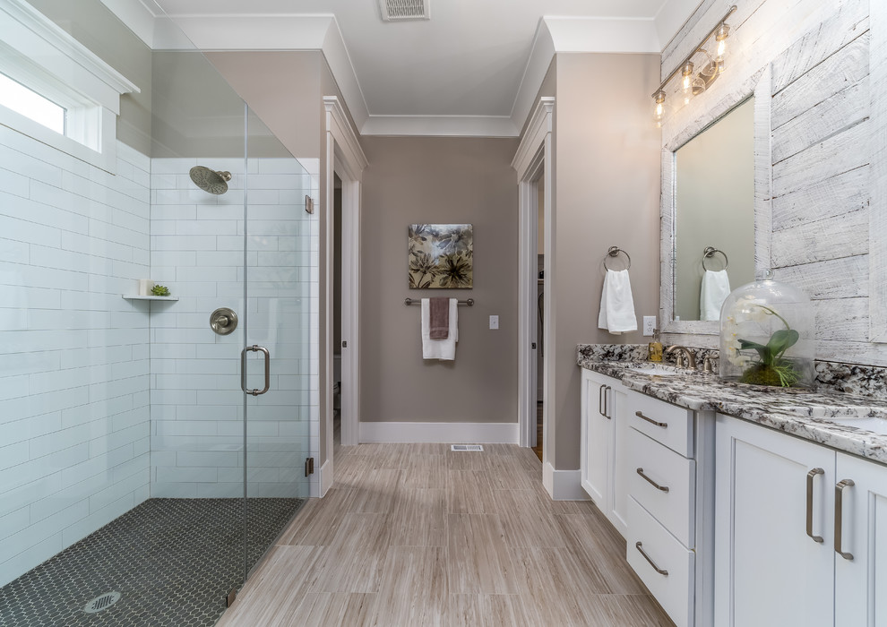 Design ideas for a farmhouse ensuite bathroom in Raleigh with recessed-panel cabinets, white cabinets, a built-in shower, white tiles, grey walls, a submerged sink, beige floors, a hinged door and grey worktops.
