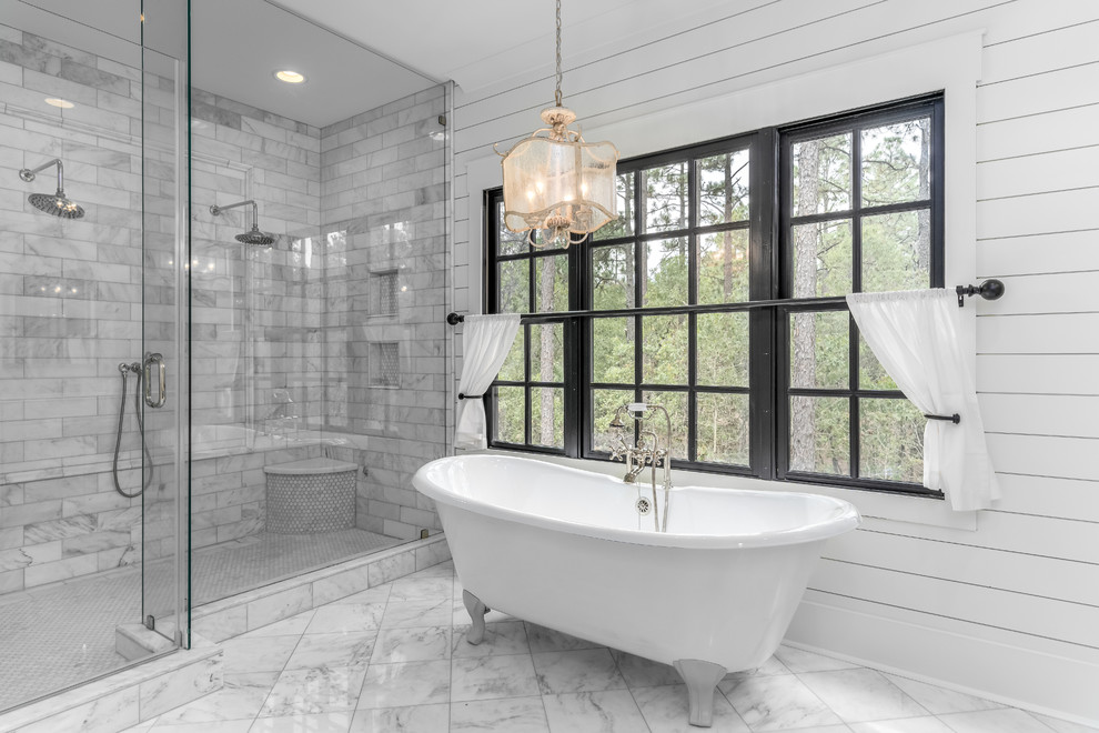 Exempel på ett lantligt badrum, med ett badkar med tassar, en hörndusch, grå kakel, vita väggar och grått golv