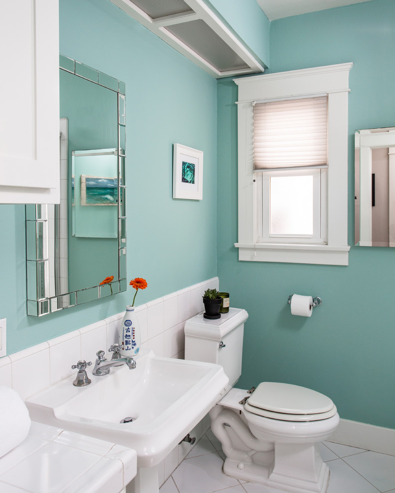 This is an example of a small traditional bathroom in Santa Barbara with white cabinets, a corner bath, a corner shower, a two-piece toilet, white tiles, porcelain tiles, blue walls, ceramic flooring, tiled worktops and a pedestal sink.