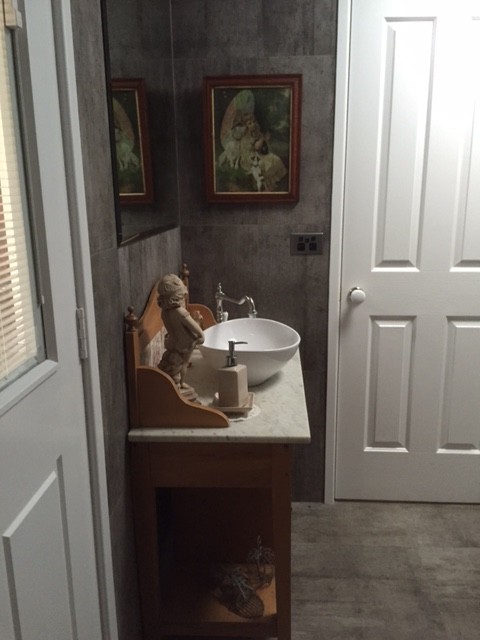 Cette photo montre une douche en alcôve principale tendance en bois brun de taille moyenne avec une vasque, un placard en trompe-l'oeil, un plan de toilette en marbre, une baignoire sur pieds, WC à poser, un carrelage gris, des carreaux de béton, un mur gris et sol en béton ciré.