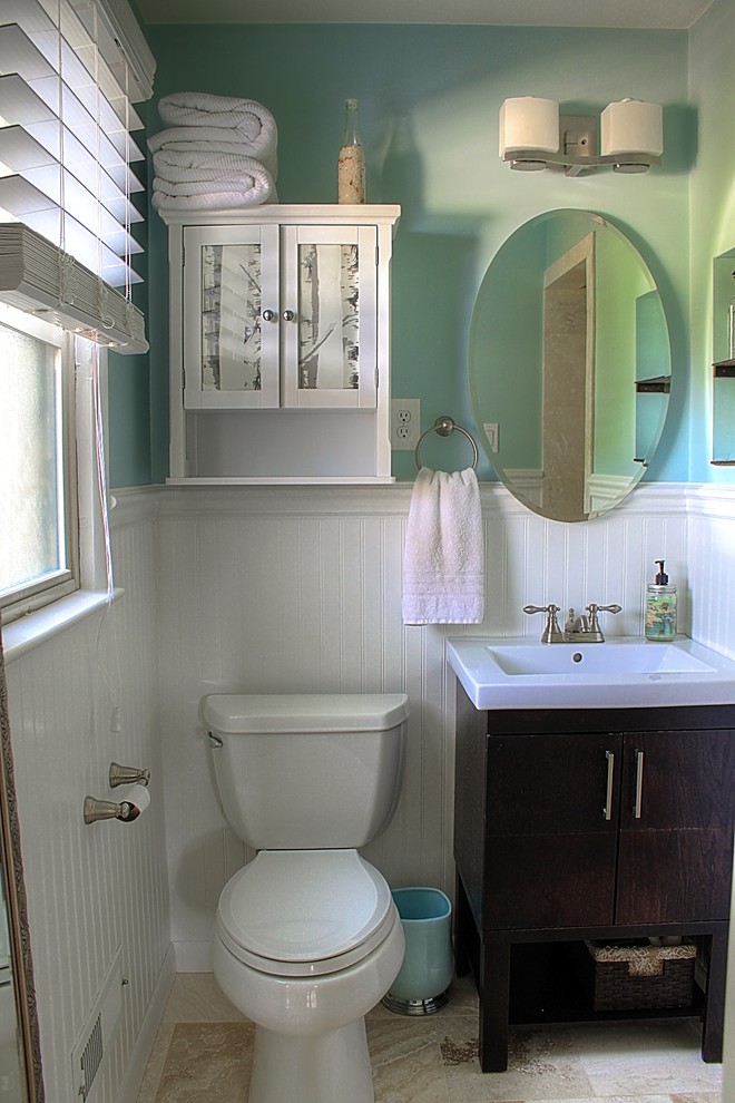 Пример оригинального дизайна: главная ванная комната среднего размера в современном стиле с раковиной с несколькими смесителями, фасадами островного типа, темными деревянными фасадами, угловым душем, унитазом-моноблоком, бежевой плиткой, каменной плиткой, синими стенами, полом из травертина, мраморной столешницей, бежевым полом, шторкой для ванной и белой столешницей