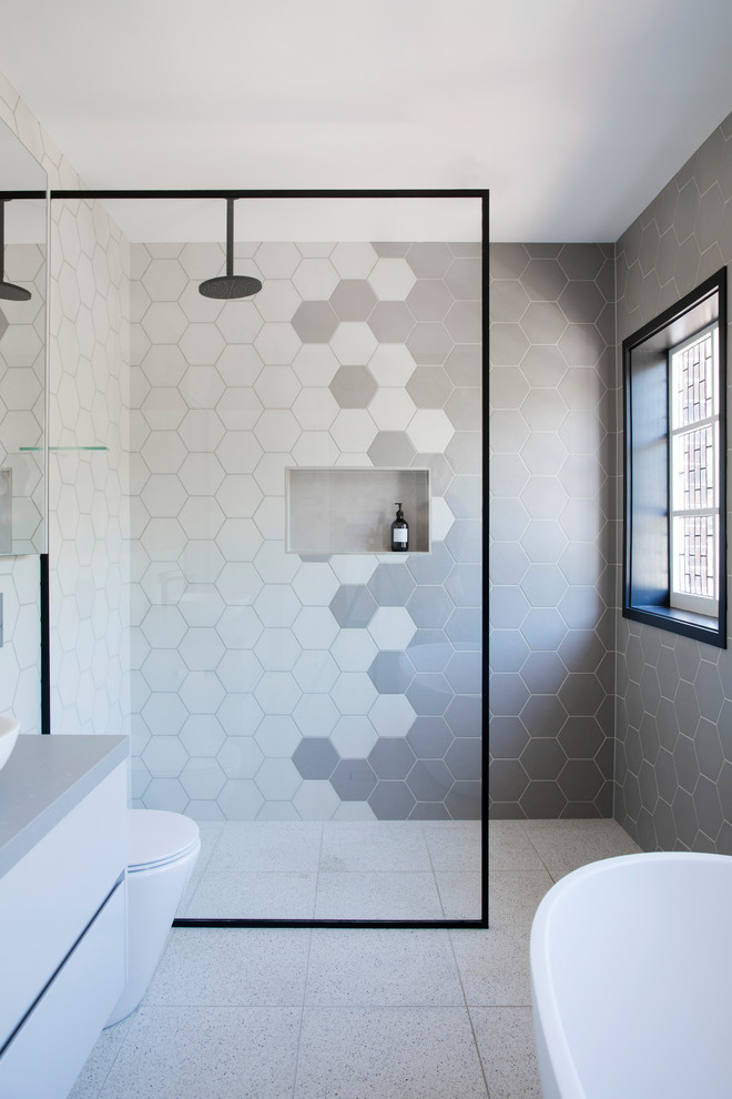 Источник вдохновения для домашнего уюта: ванная комната в стиле неоклассика (современная классика) с плоскими фасадами, белыми фасадами, отдельно стоящей ванной, серой плиткой, серым полом и серой столешницей